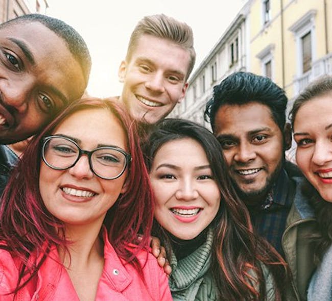 A group of diverse-looking people smile at the camera.
