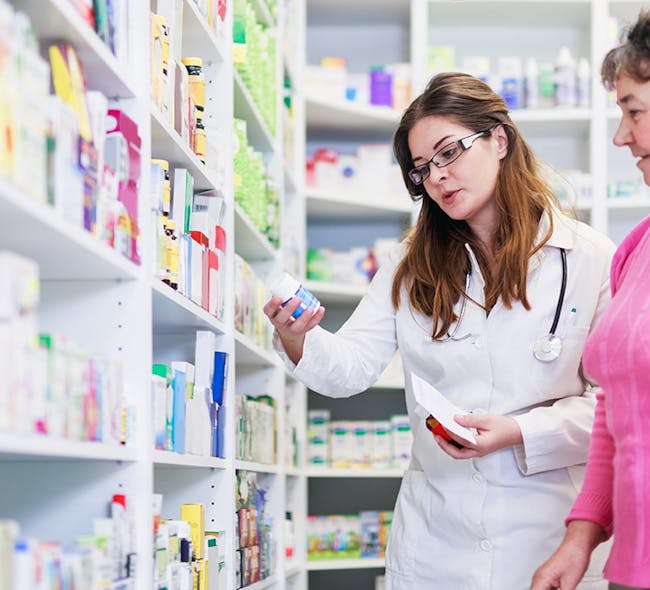 A pharmacist helps a woman choose her medication.