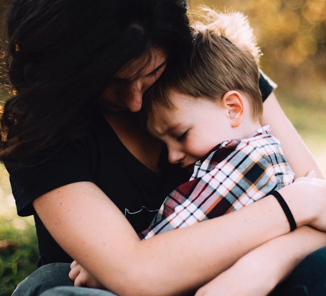A child receiving Burrell's youth support services is hugged by his mom.