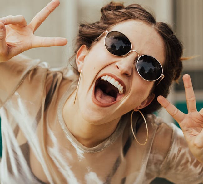 Woman with sunglasses on laughing.