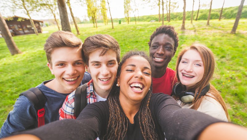A group of teens smile together.